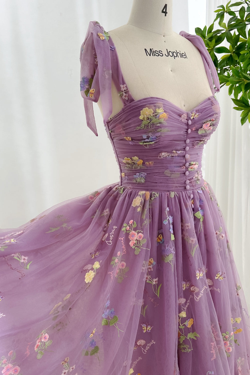 Vestido con bordado floral y corsé con aberturas y mangas anudadas