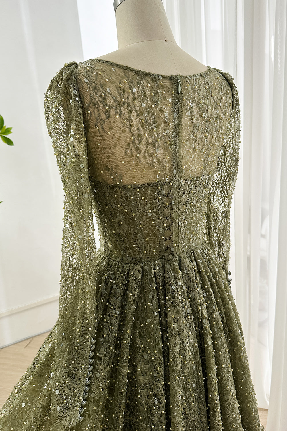 Close up of back illusion lace design with shimmering sequins structured bodice and elegant olive tone fabric suitable for formal events