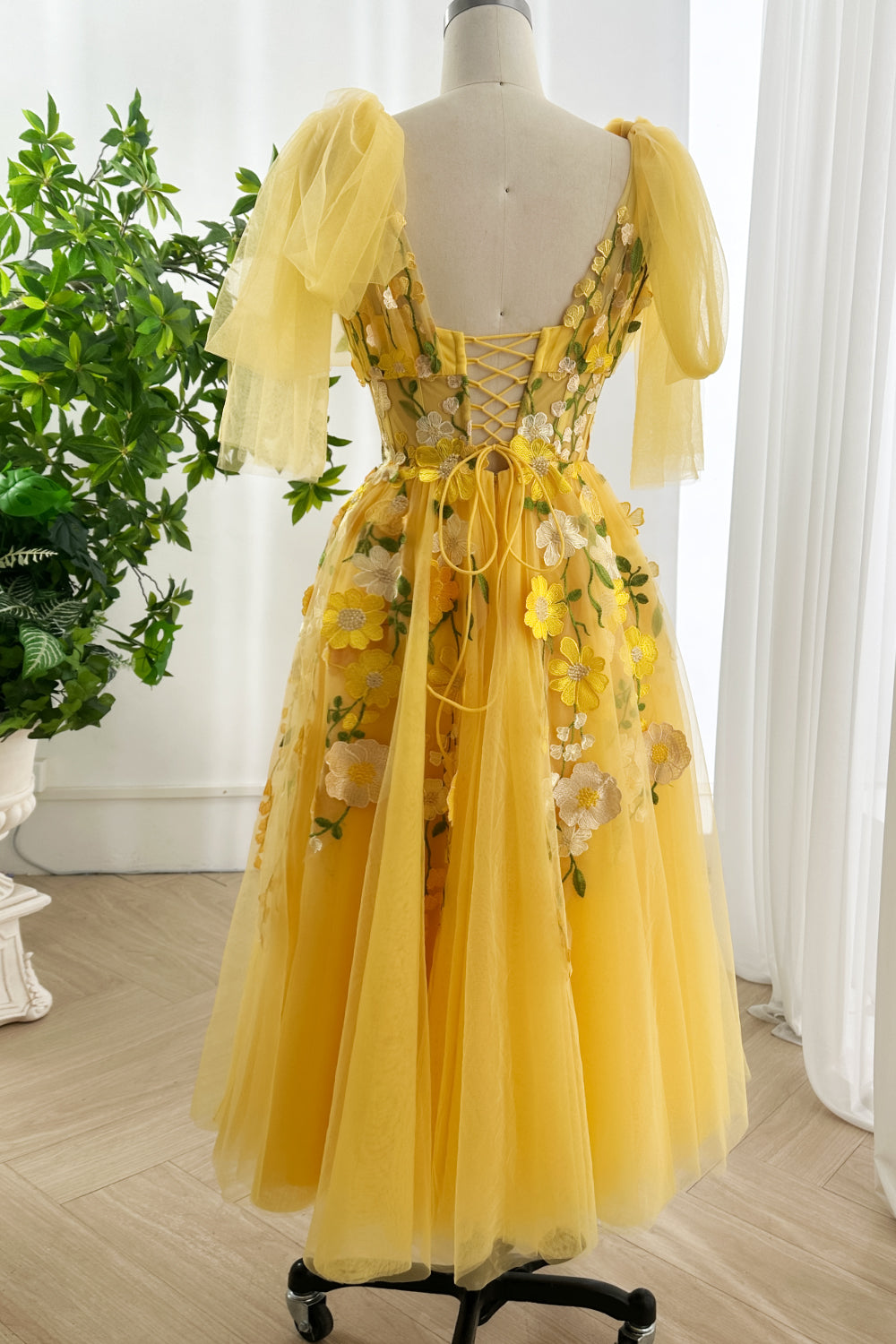 Sunlit botanical masterpiece gown displayed rear angle capturing dreamy tulle movement embroidery artistry cascading beautifully throughout composition