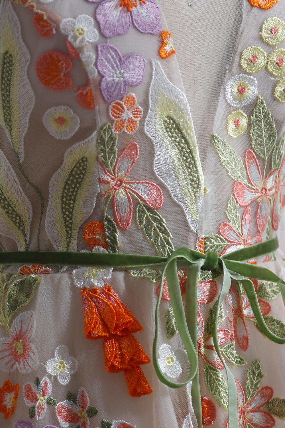 Closeup botanical threadwork fashion detail presenting dimensional petals vivid stitching tactile ornamentation luxurious handmade surface composition