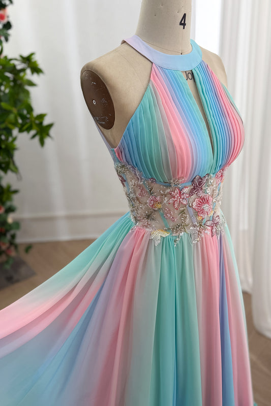 Vestido de gasa en tonos pastel con cuello halter, corpiño plisado, cintura floral con cuentas y falda fluida a rayas en un estudio luminoso.