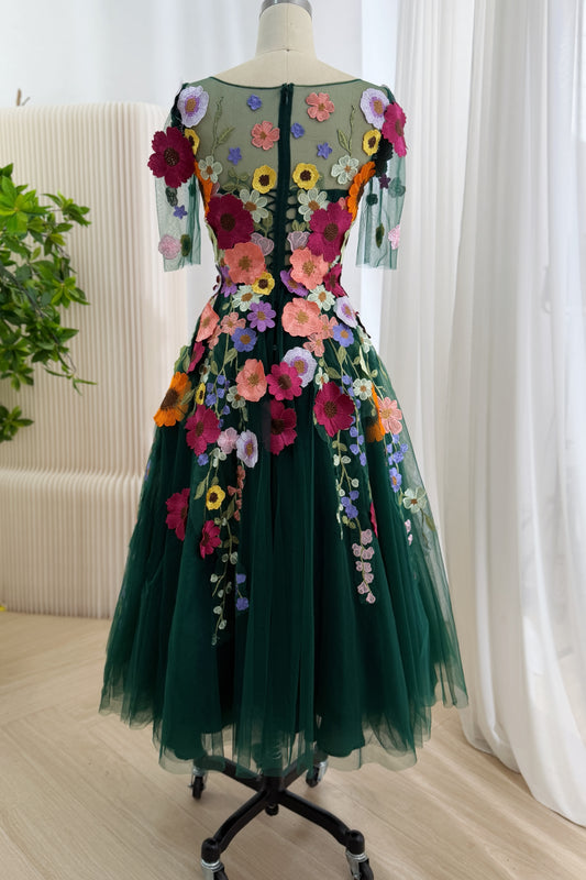 Rear view of pine tulle gown featuring illusion yoke, corset lacing, zip closure, botanical appliques, graceful midi hemline.