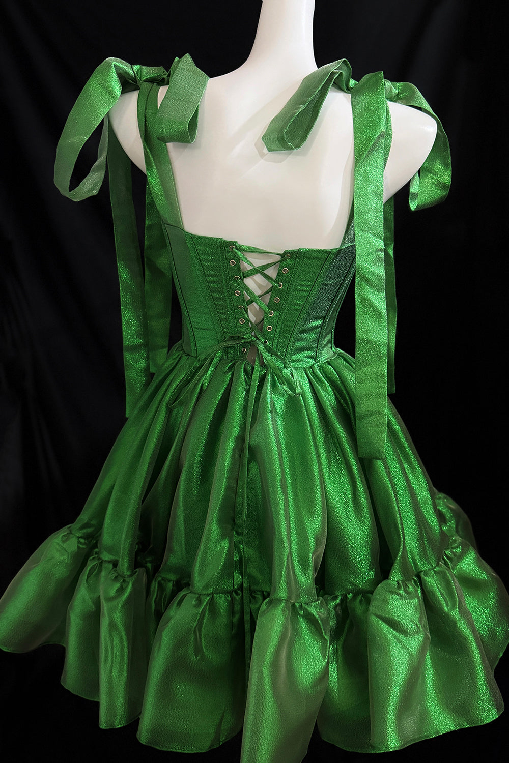 Vestido de organza verde brillante con capas y tirantes para atar.
