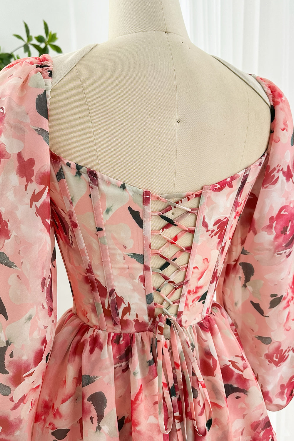 Detailed back view floral chiffon corset dress in pink with lace-up closure and puff sleeves ideal for romantic occasions, parties and celebrations