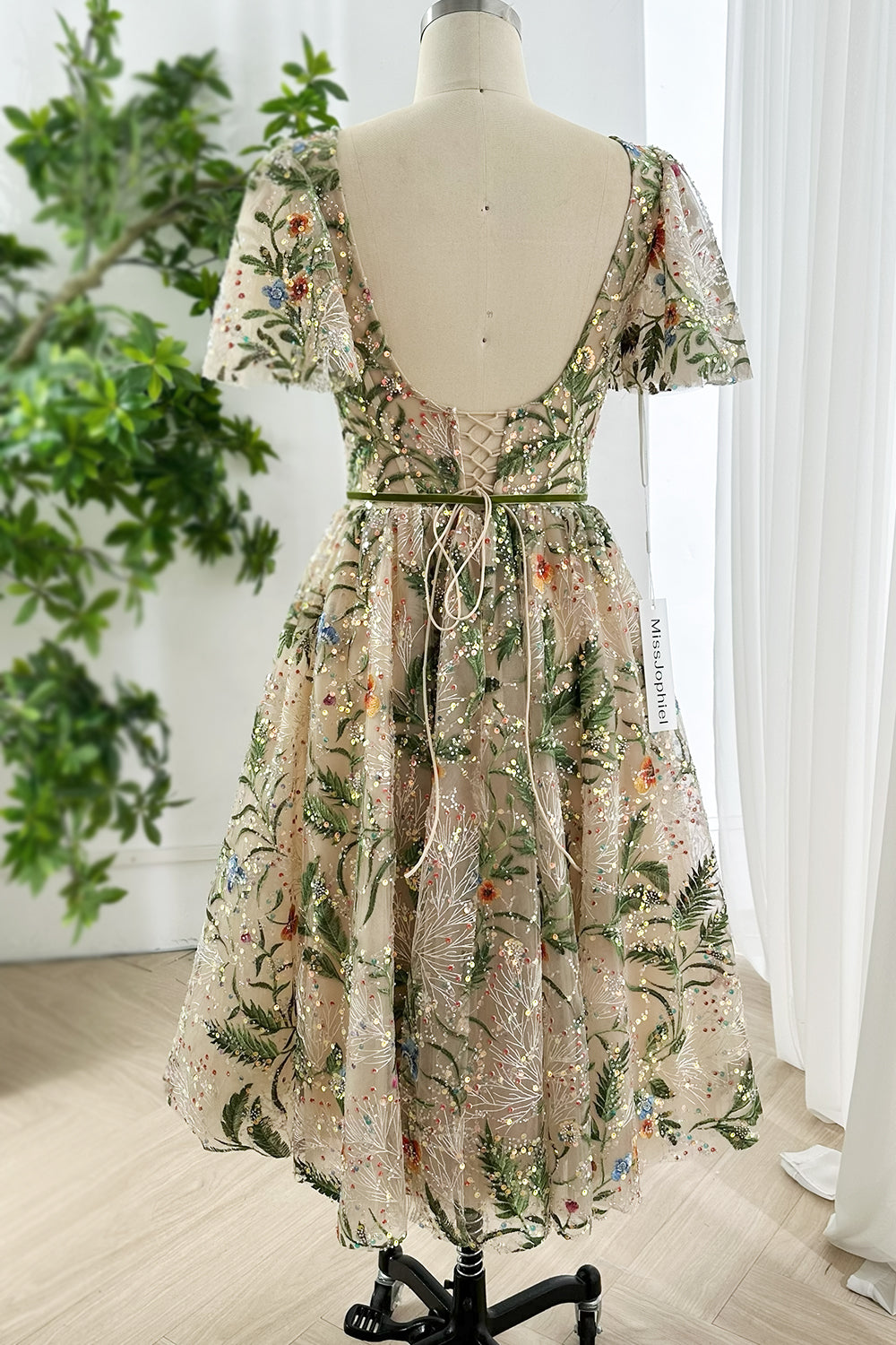 Vintage inspired floral embroidered sequin mesh midi dress displayed from back featuring lace up closure deep scoop neckline and green waist tie