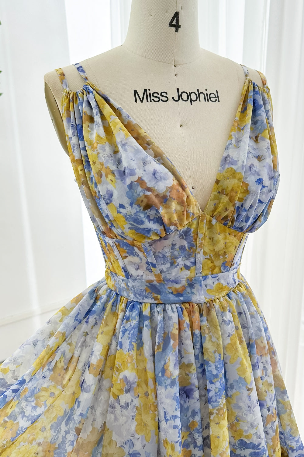 Chiffon summer dress with bold floral print, structured bodice, V-neck, and lace-up back designed for stylish vacation occasions