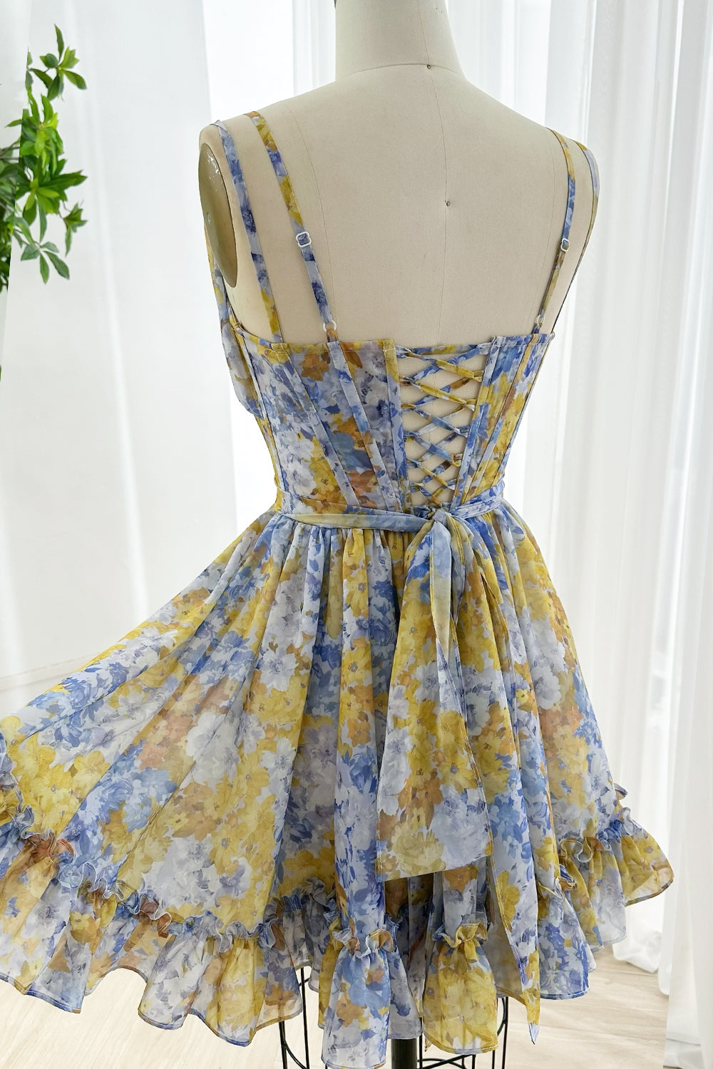 Back view showing corset lace-up detail on chiffon floral dress with adjustable straps and tie sash ideal for chic summer events