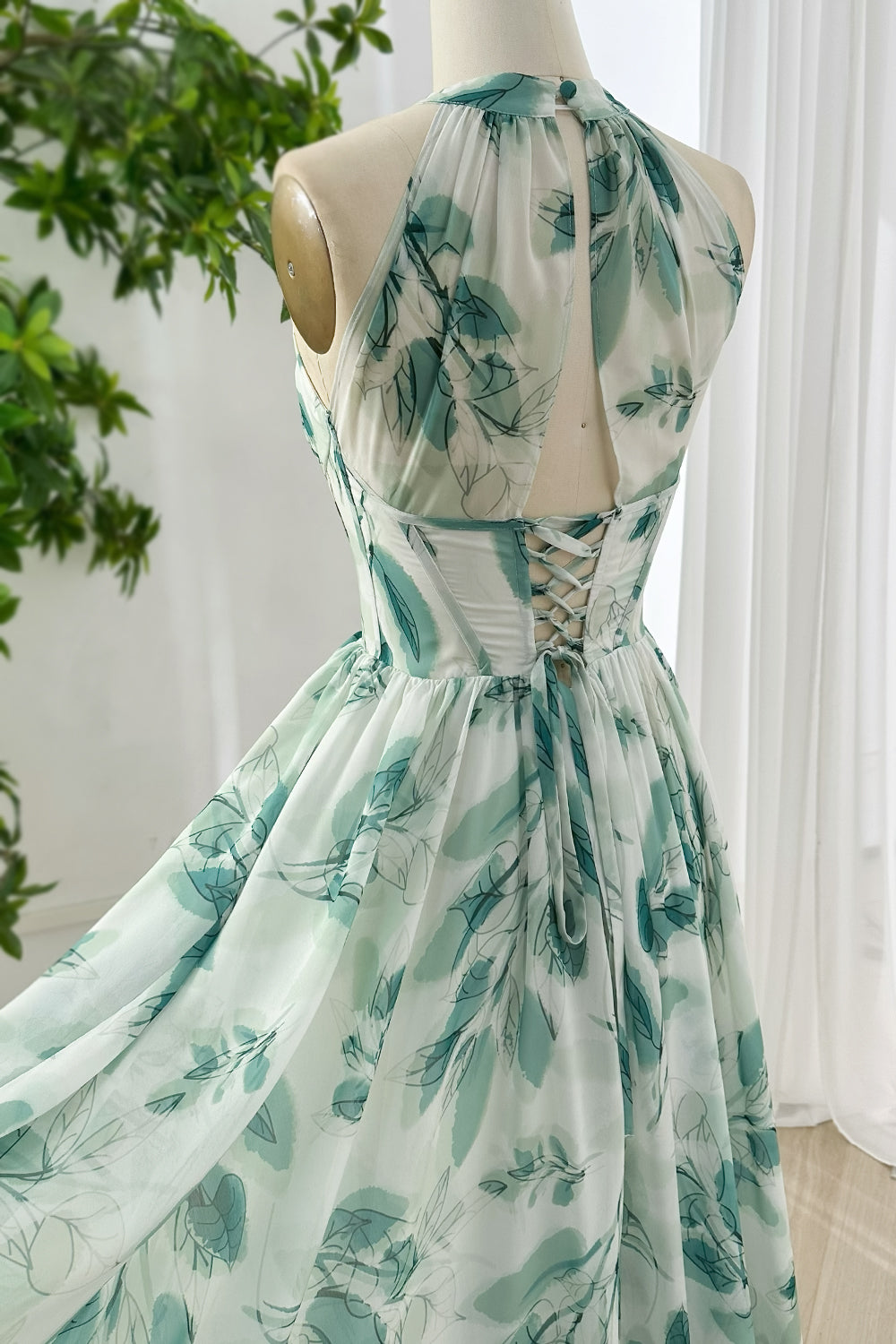 Backless lace up chiffon maxi dress with halter neckline and green botanical leaf print for summer wedding reception styling