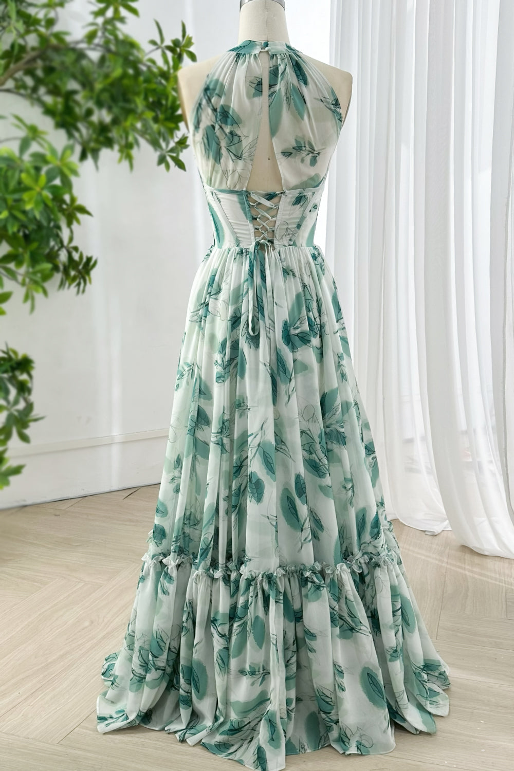 Romantic chiffon evening gown with high neck halter design and lace up open back featuring green watercolor leaves print
