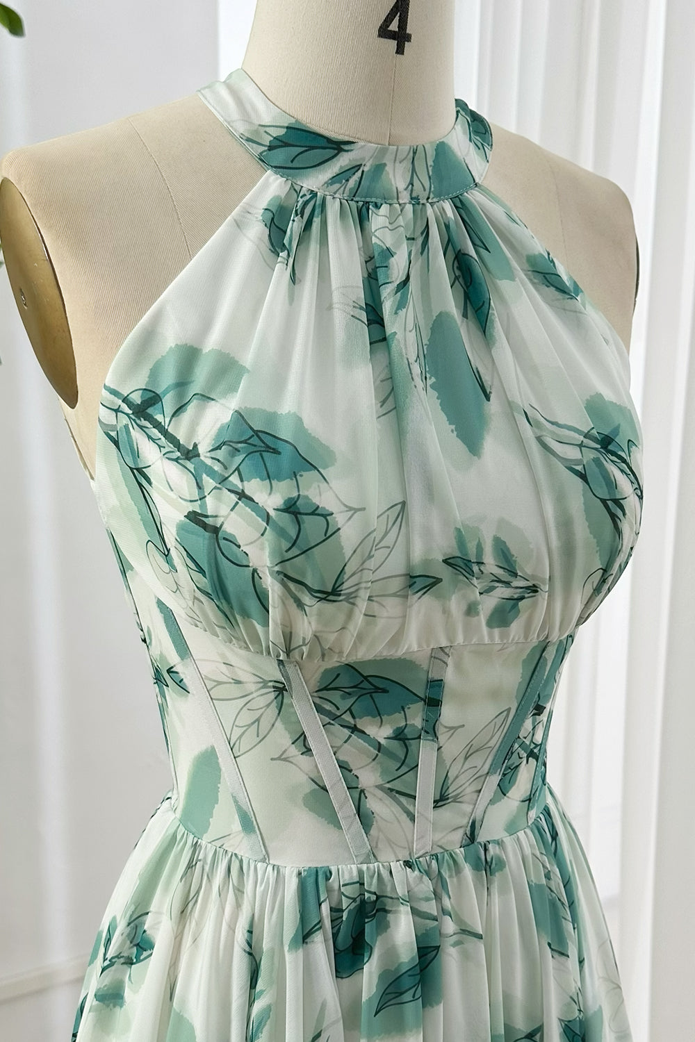 Flowy corset halter maxi gown with pleated bodice and green leaf pattern chiffon fabric ideal for formal outdoor garden occasions