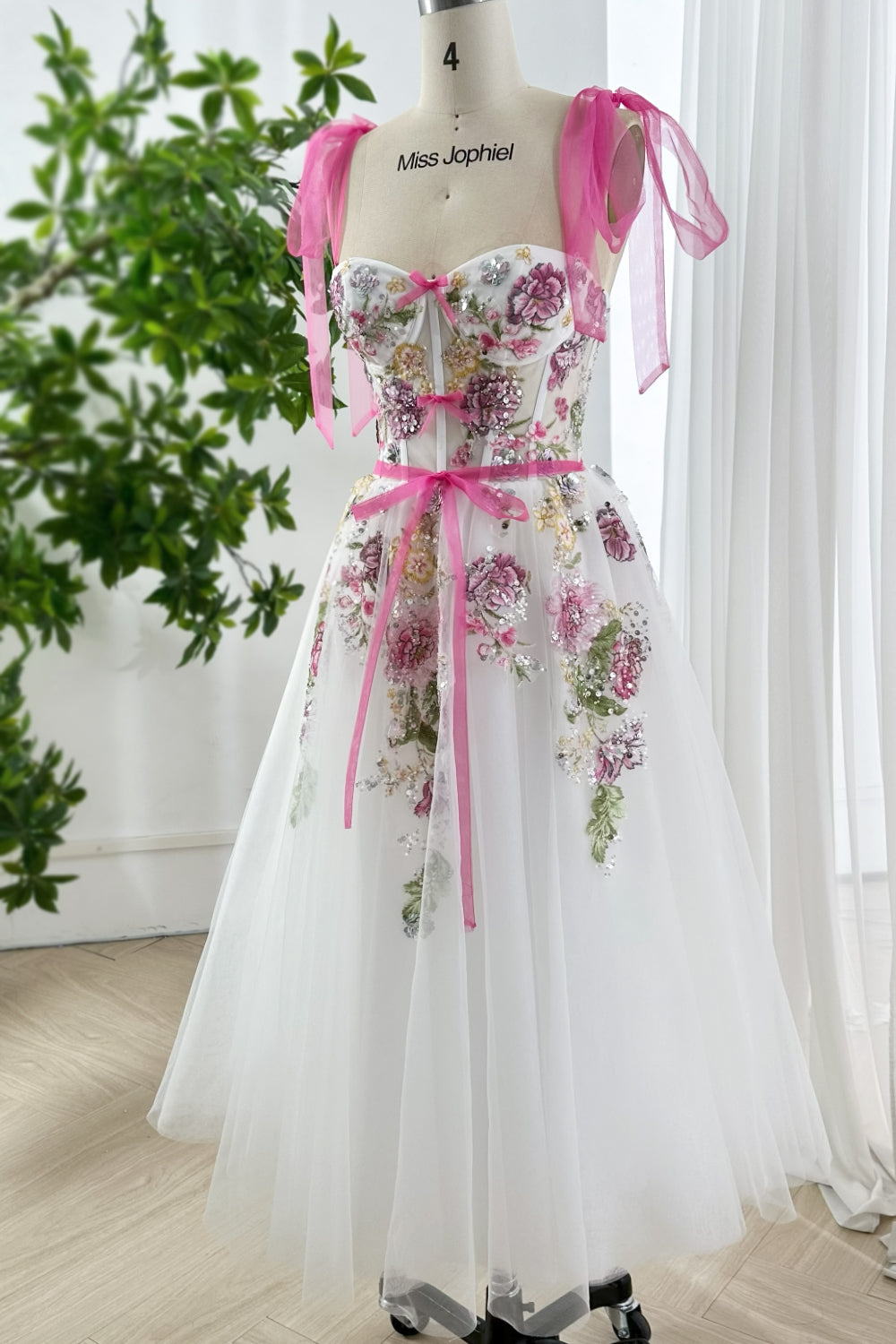Romantic illusion bodice bridal shower dress with floral embroidery, sequins, and soft tulle skirt styled on mannequin angled view