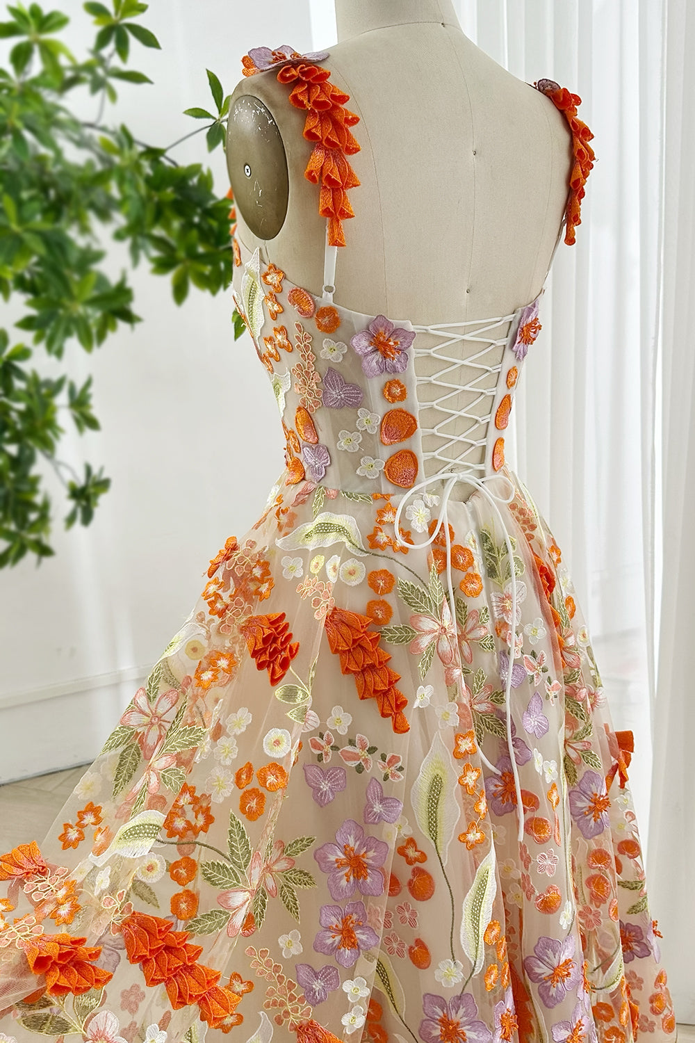 Back view lace-up closure floral embroidered dress featuring colorful blooms orange lilac ivory with flowing skirt