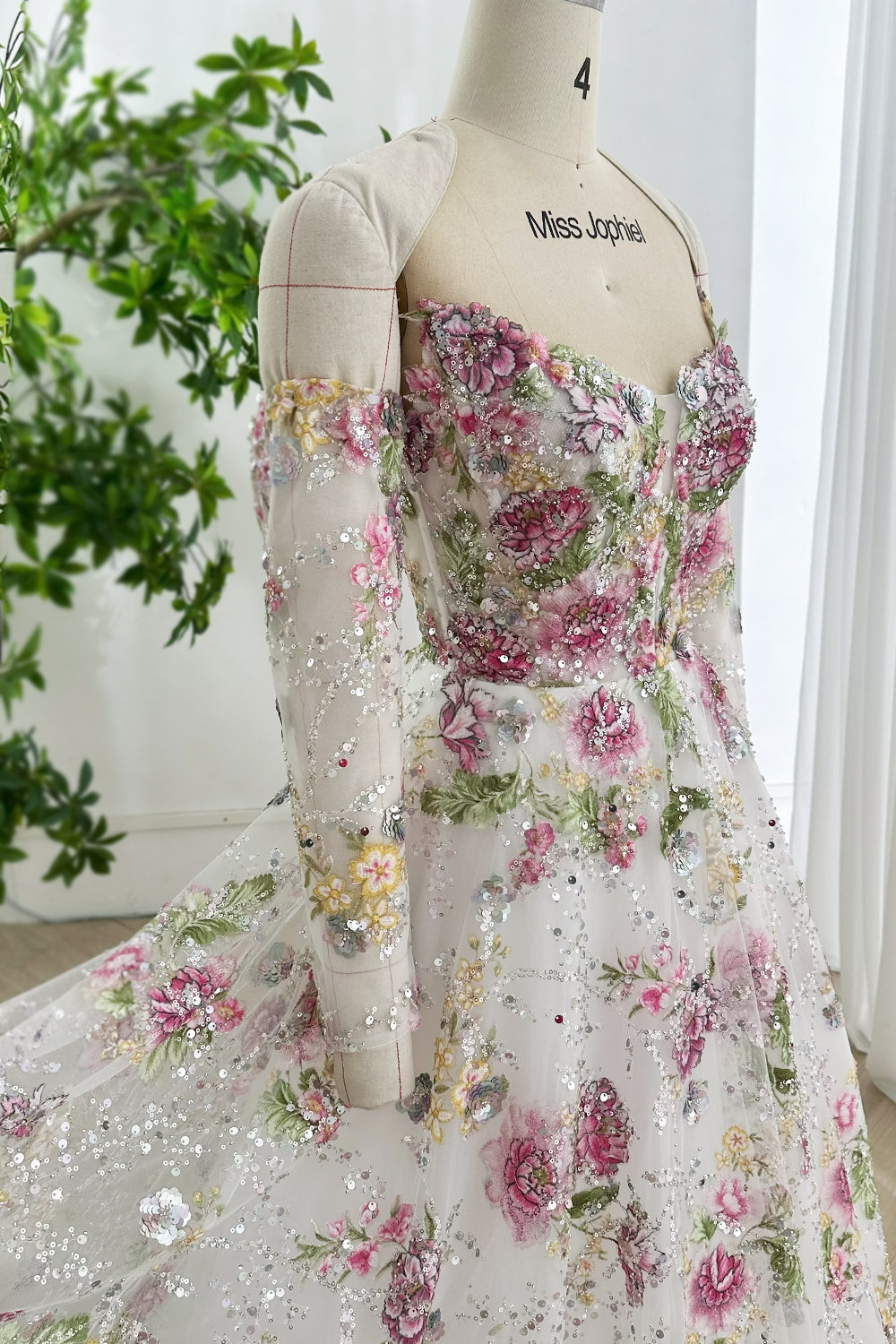 Sideview corseted-bodice botanical-beading illusion-sleeve pink-peony motifs tulle-overlay on atelier-manikin shimmer-detail!
