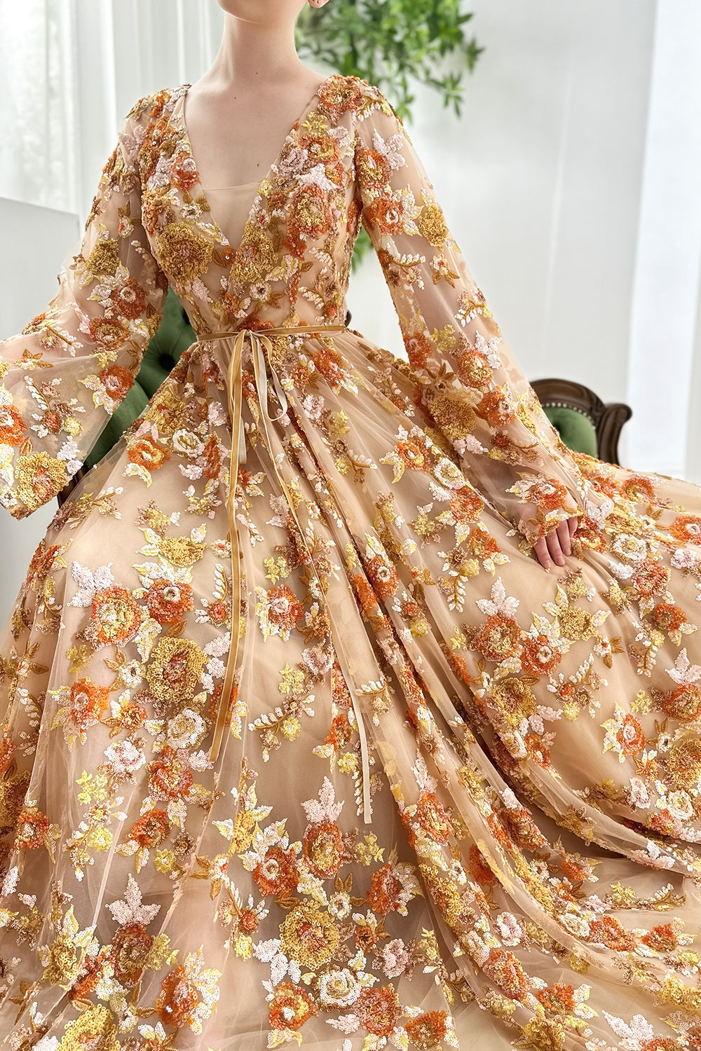 Luxe-goldenrod sequinwork panoramic-movement layered-panels corded-sash cinematic-pose studio-setting leafy-backdrop