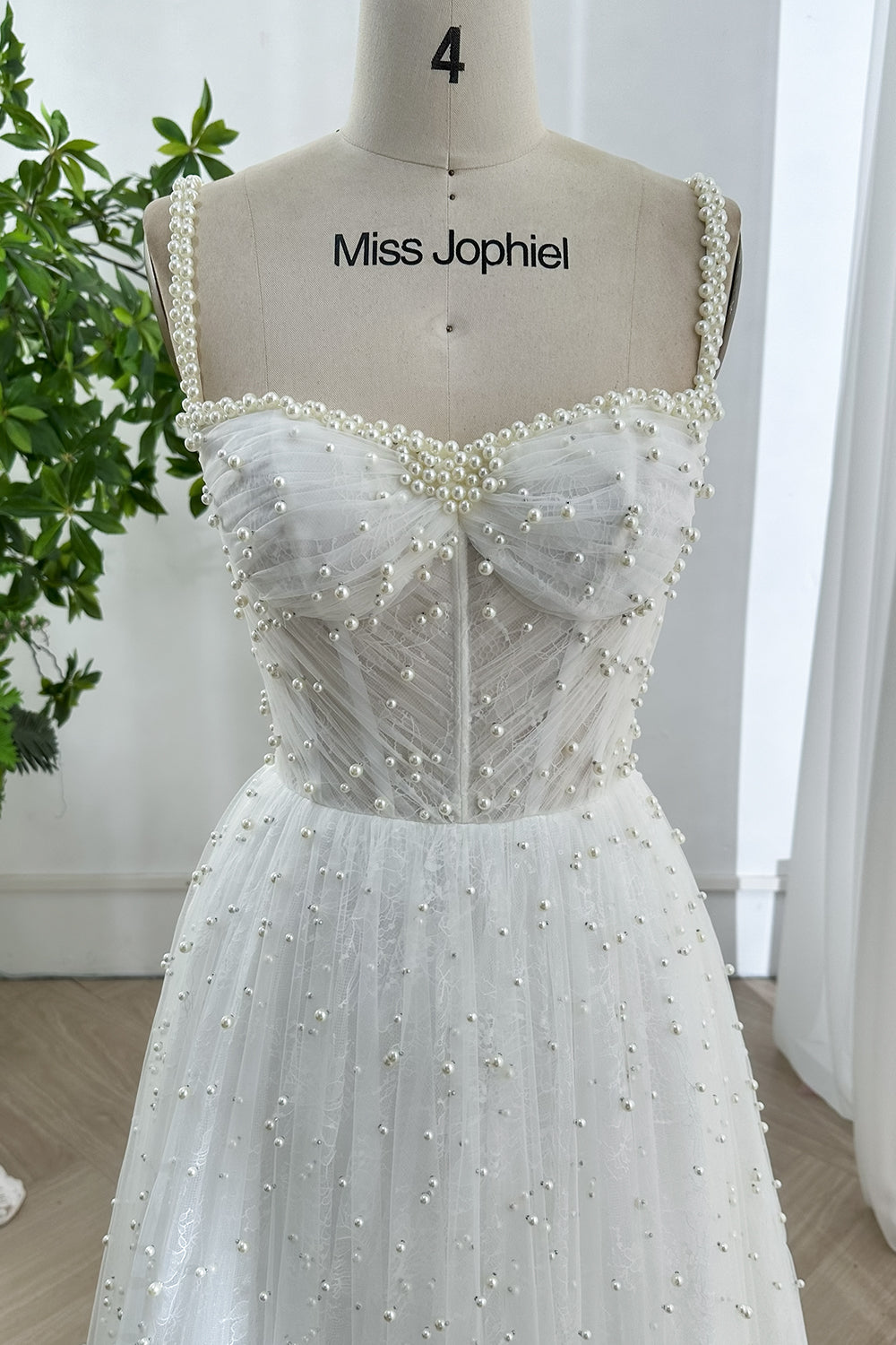Detailed view of handcrafted pearl tulle corset wedding dress with sweetheart neckline and romantic A-line flow