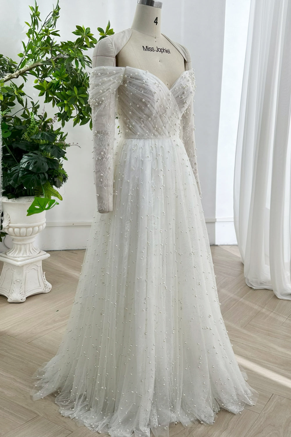 Modern elegant wedding gown with lace up back pearl embroidery flowing full length skirt designed for contemporary elegant ceremony brides