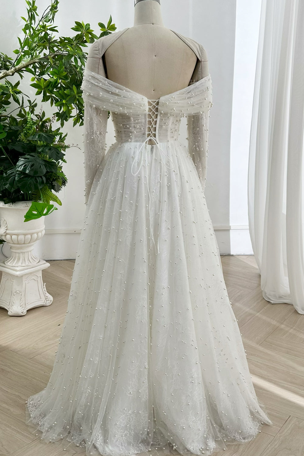 Luxury lace pearl floor length wedding dress with lace up back soft flowing skirt ideal for sophisticated brides timeless romantic weddings