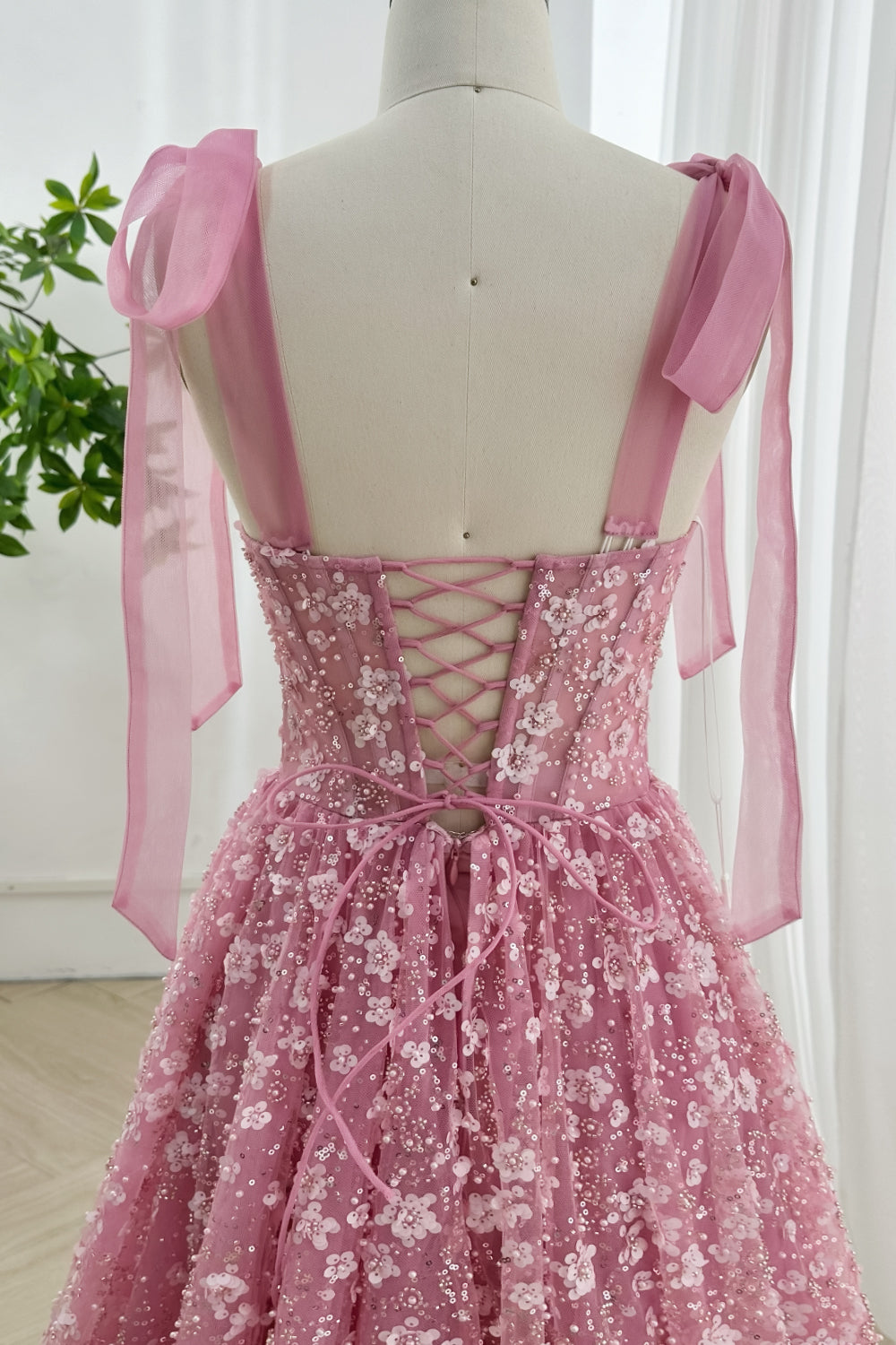Dusty pink sequin flower evening gown close-up of lace-up back and 3D floral embroidery with flowing tulle and ribbon straps