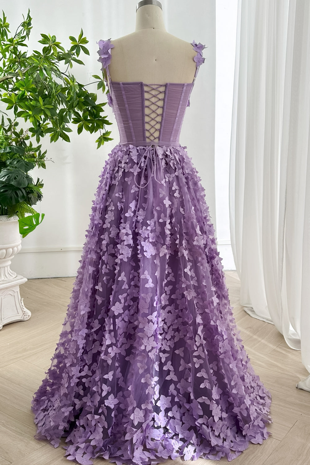 Back view of lavender floral evening gown featuring lace-up corset closure and flowing floor length skirt for elegant profile