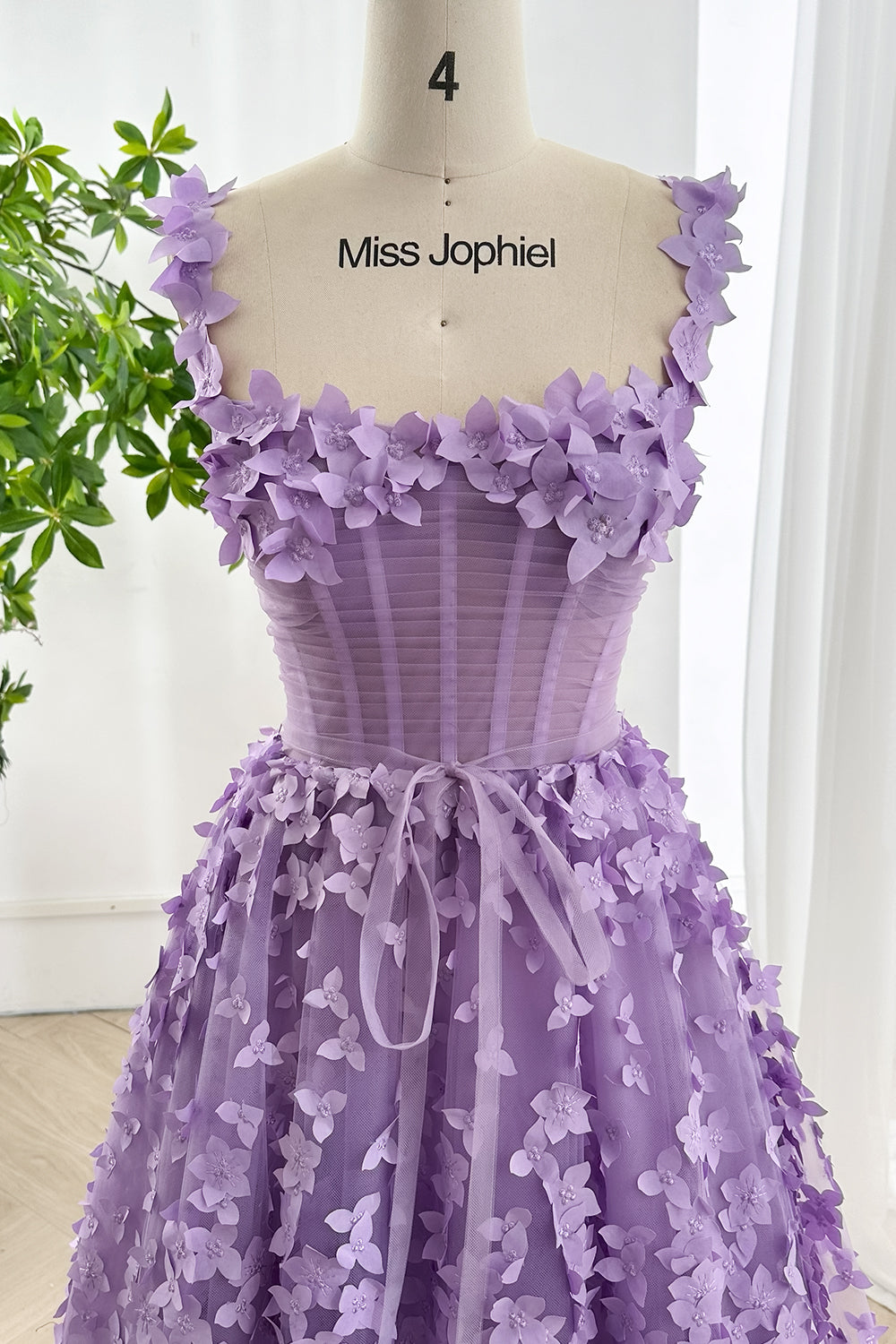 Lavender tulle corset dress showing intricate 3D floral appliqué craftsmanship and soft layered fabric texture in close focus