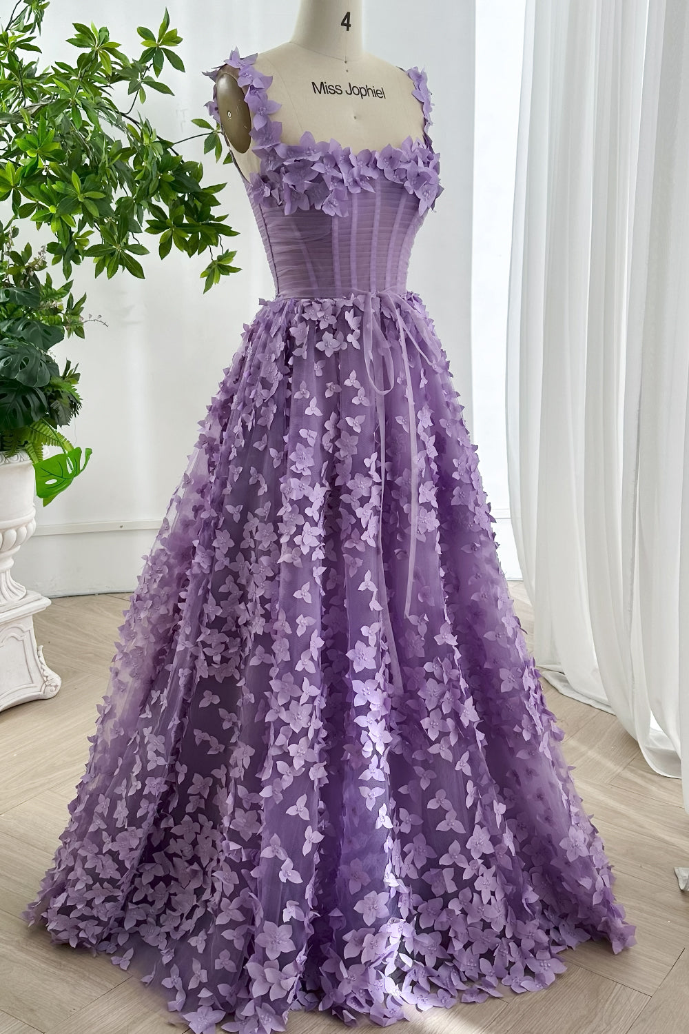 Romantic lavender tulle gown with structured corset bodice and 3D flower straps displayed on mannequin for formal evening look