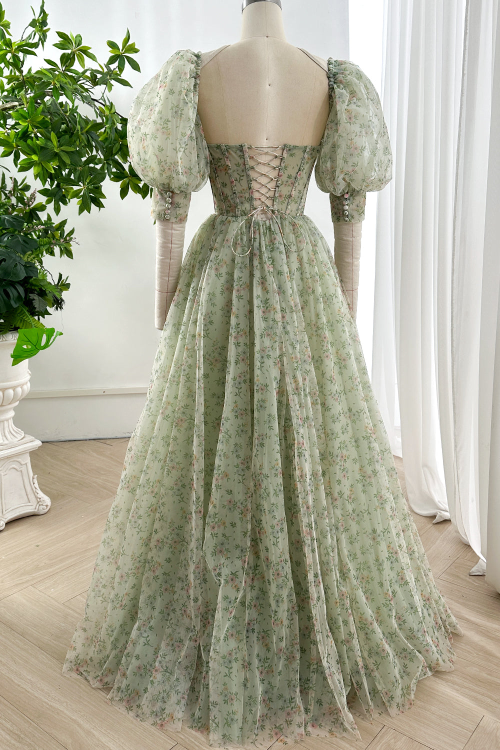 Back view of flower pattern corset lace up green tulle maxi dress with puff sleeves and fitted waistline creating romantic silhouette