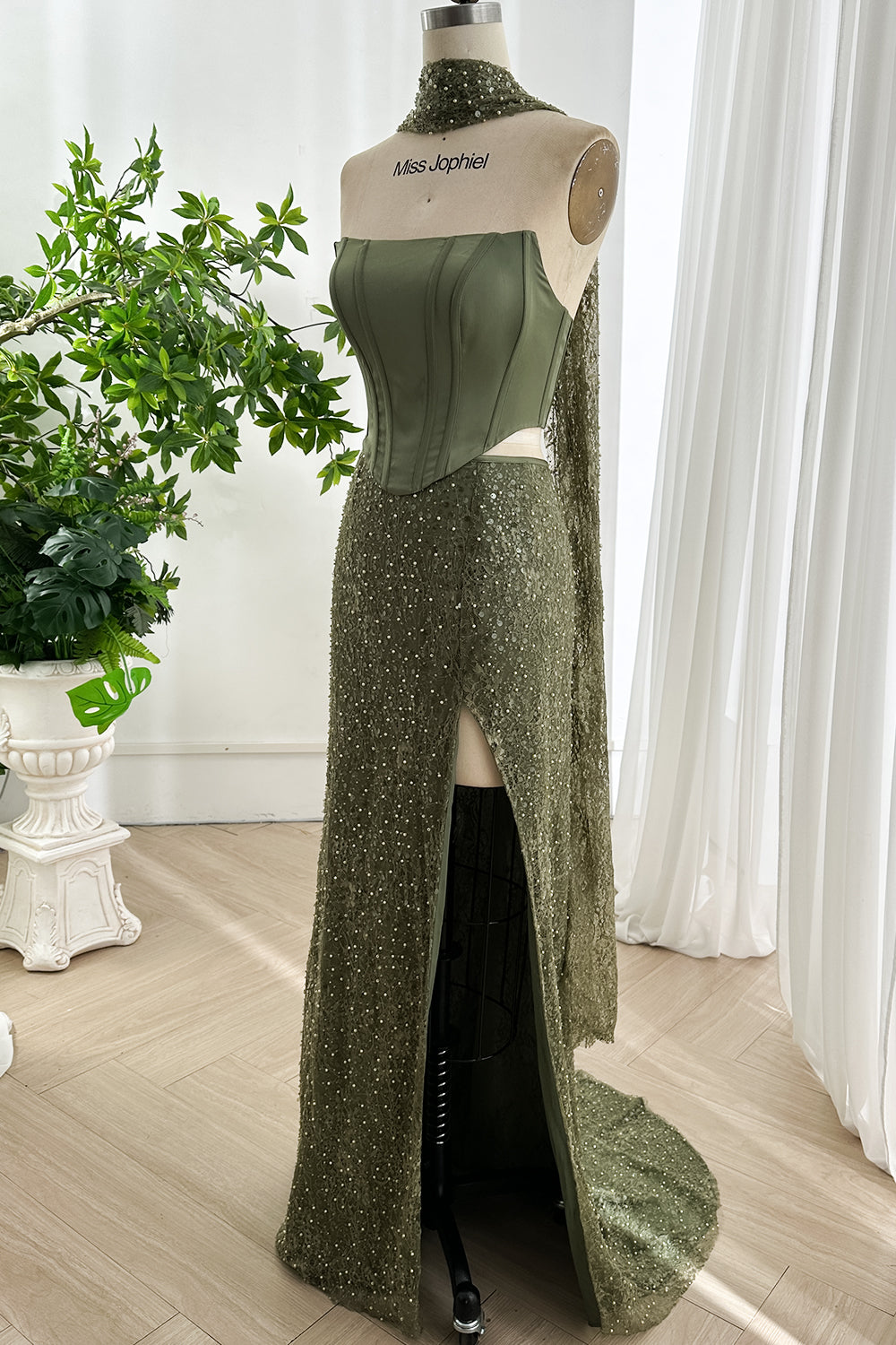 Side view of olive green two piece formal dress featuring structured corset bodice and shimmering beaded slit skirt design