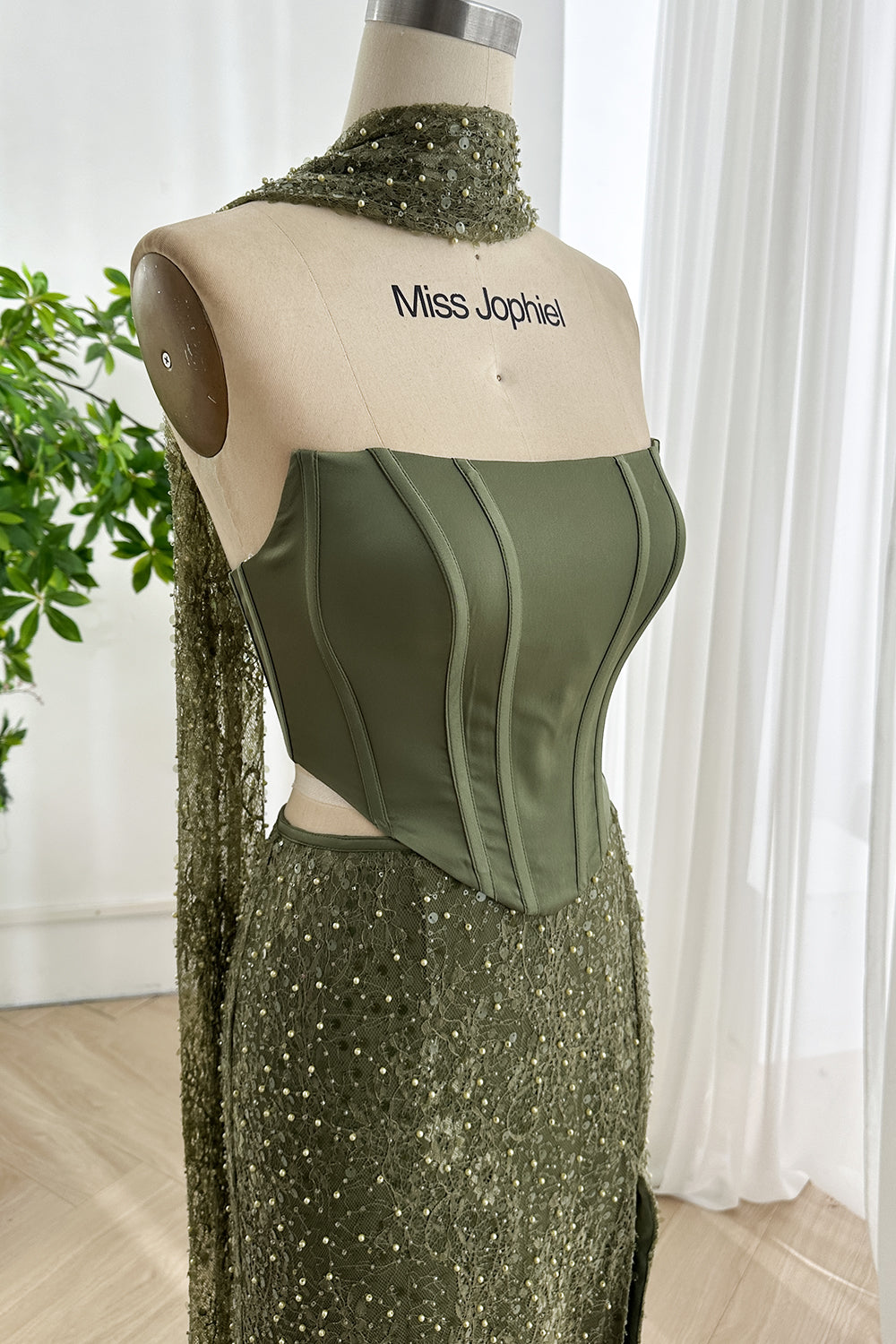 Close up of satin corset top from olive green two piece dress with structured boning and smooth tailored lines
