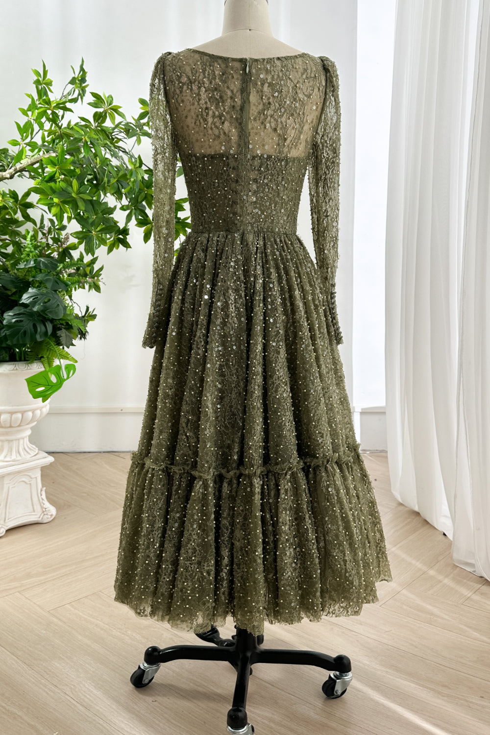 Back view of olive lace dress showcasing shimmering sequins tiered skirt sheer long sleeves and invisible back zipper for refined look