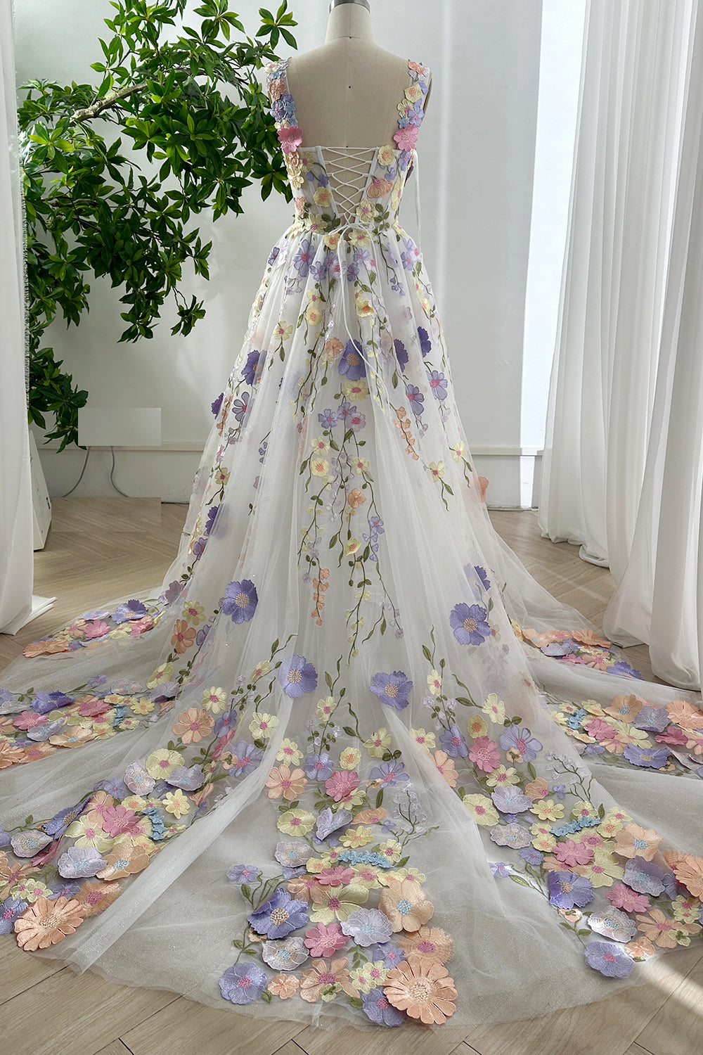 Back view of pastel glitter floral tulle gown with lace-up corset design and sparkling cathedral train for bridal occasions