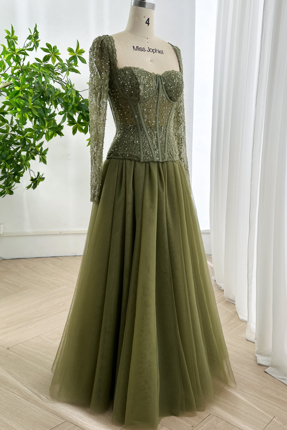 Side view of vintage inspired olive green formal ball gown with structured lace corset and soft flowing tulle skirt