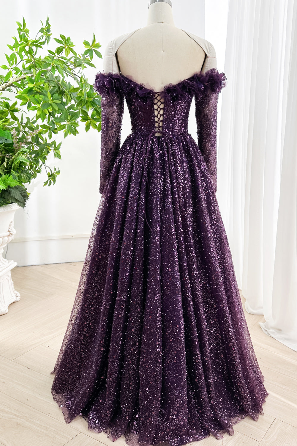 Back view of dark purple sequin gown with lace-up corset closure and off-shoulder ruffled neckline for formal occasions