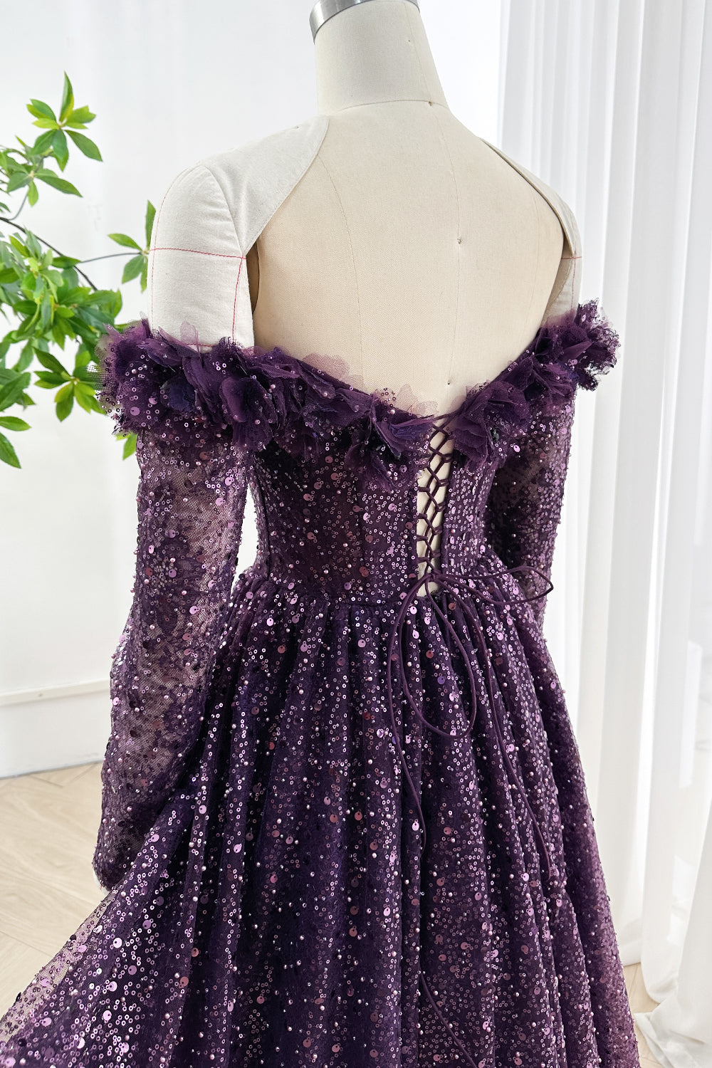 Detailed back angle of deep purple sequin gown showing lace-up corset and tulle ruffled neckline accent for elegant events
