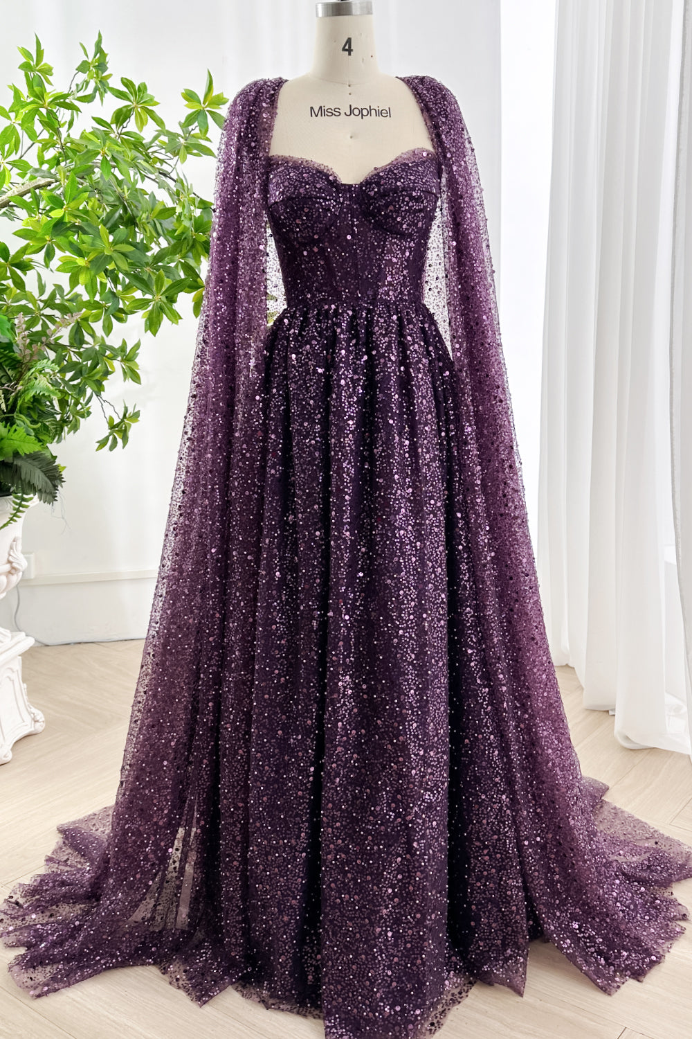 Dark purple sequin gown with sweetheart corset bodice and detachable cape displayed on mannequin Miss Jophiel for luxury evening fashion