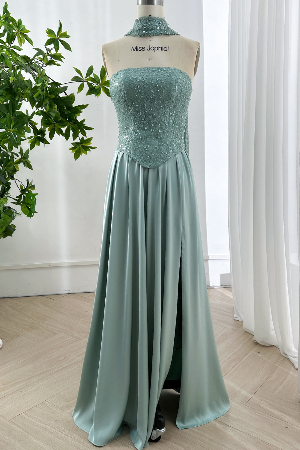 Radiant full length mint gown showcased with shimmering textured upper corset paired flowing skirt exuding refined sophistication studio ambiance