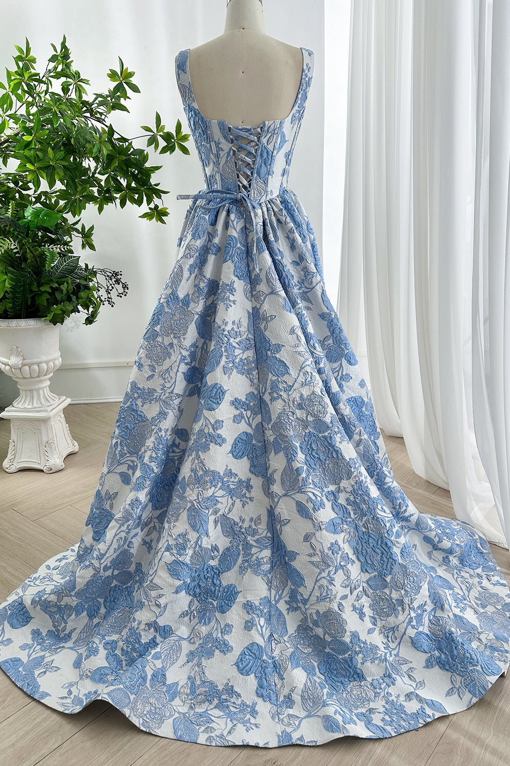 Rear perspective elegant long train flowing from cinched waist couture outfit.
