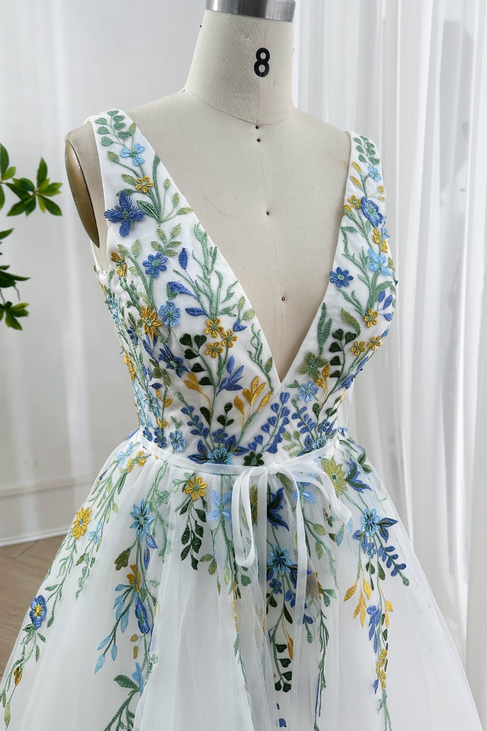 Detailed blue yellow wildflowers stitching bodice close-up mesh nature-inspired colorful botanical pattern artisan
