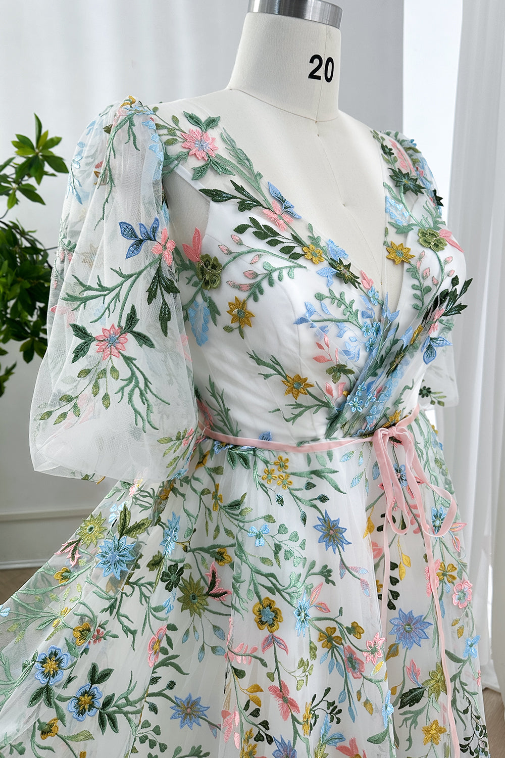 MissJophiel whimsical white tulle gown featuring colorful wildflower embroidery and delicate pink ribbon sash for garden events.