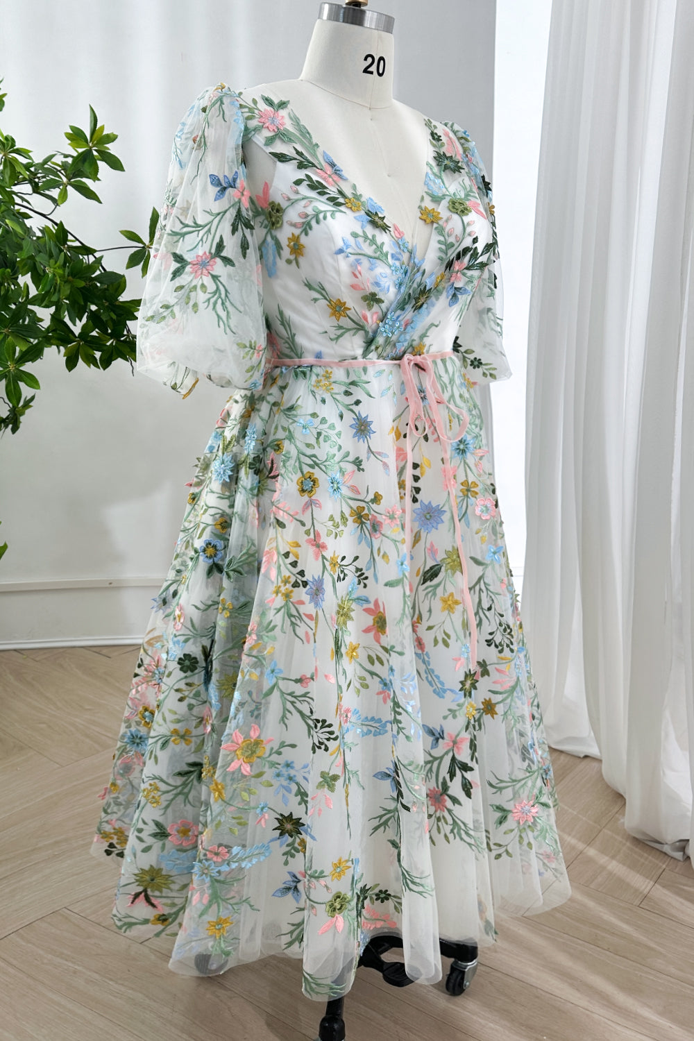 Ethereal midi length dress showcasing intricate multi-color floral stitching on layered mesh fabric with flattering V-neckline.