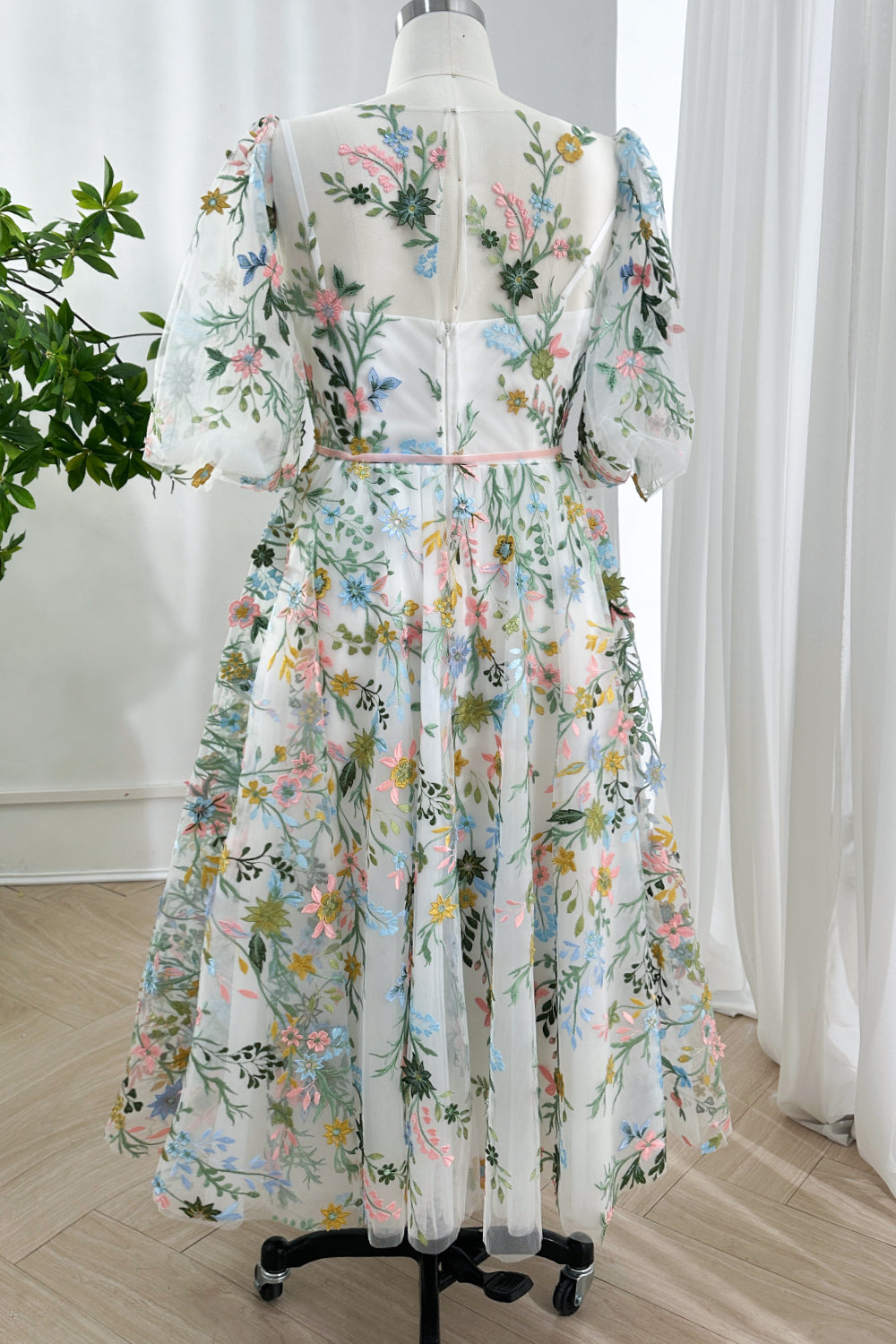 Back view of enchanting cottagecore attire displaying invisible zipper closure exhibiting puffed elbow-length sleeves sheer.