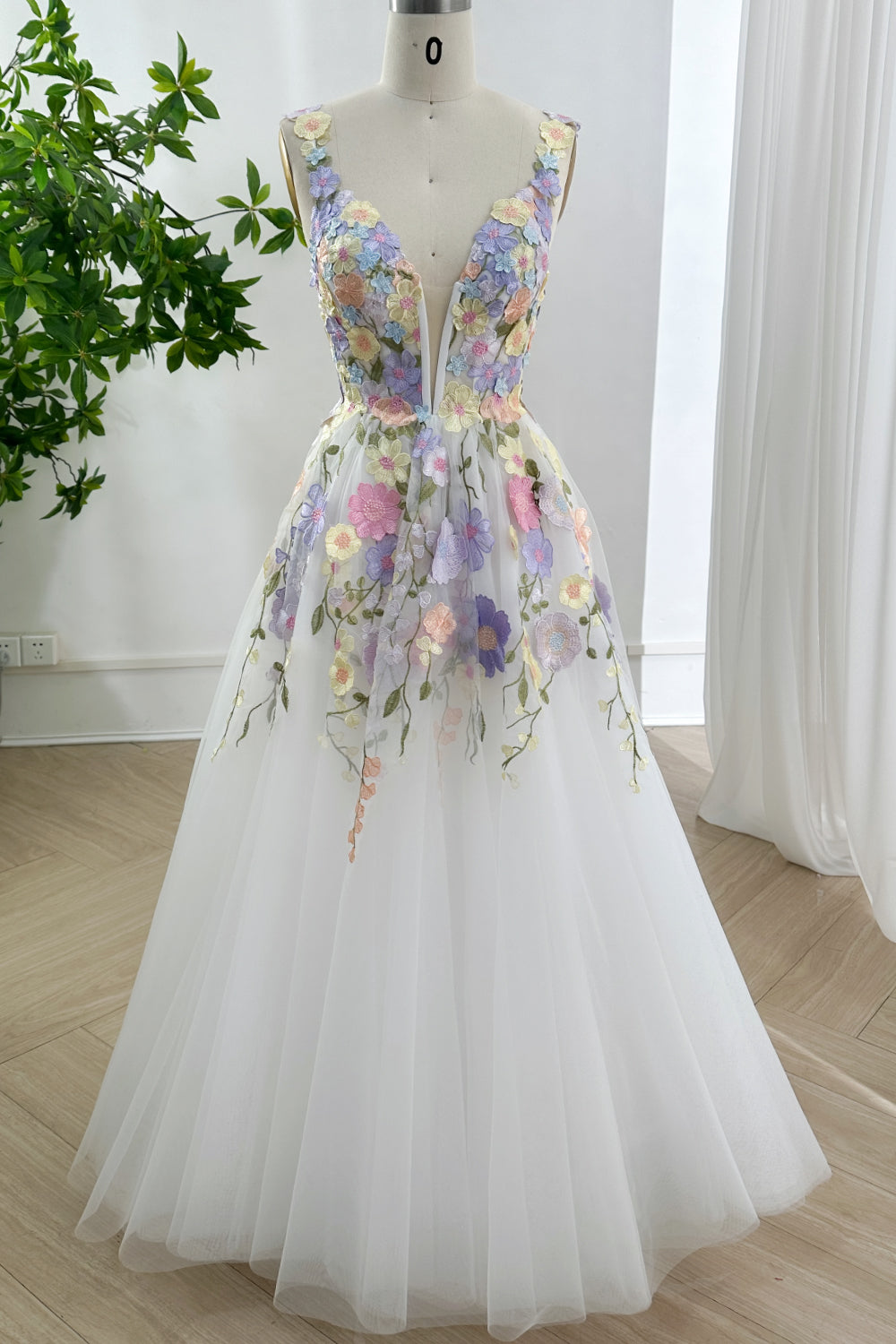 Ethereal pastel botanical bridal aesthetic gown showcased frontally upon mannequin highlighting plunging illusion bodice embroidery tulle skirt serenity