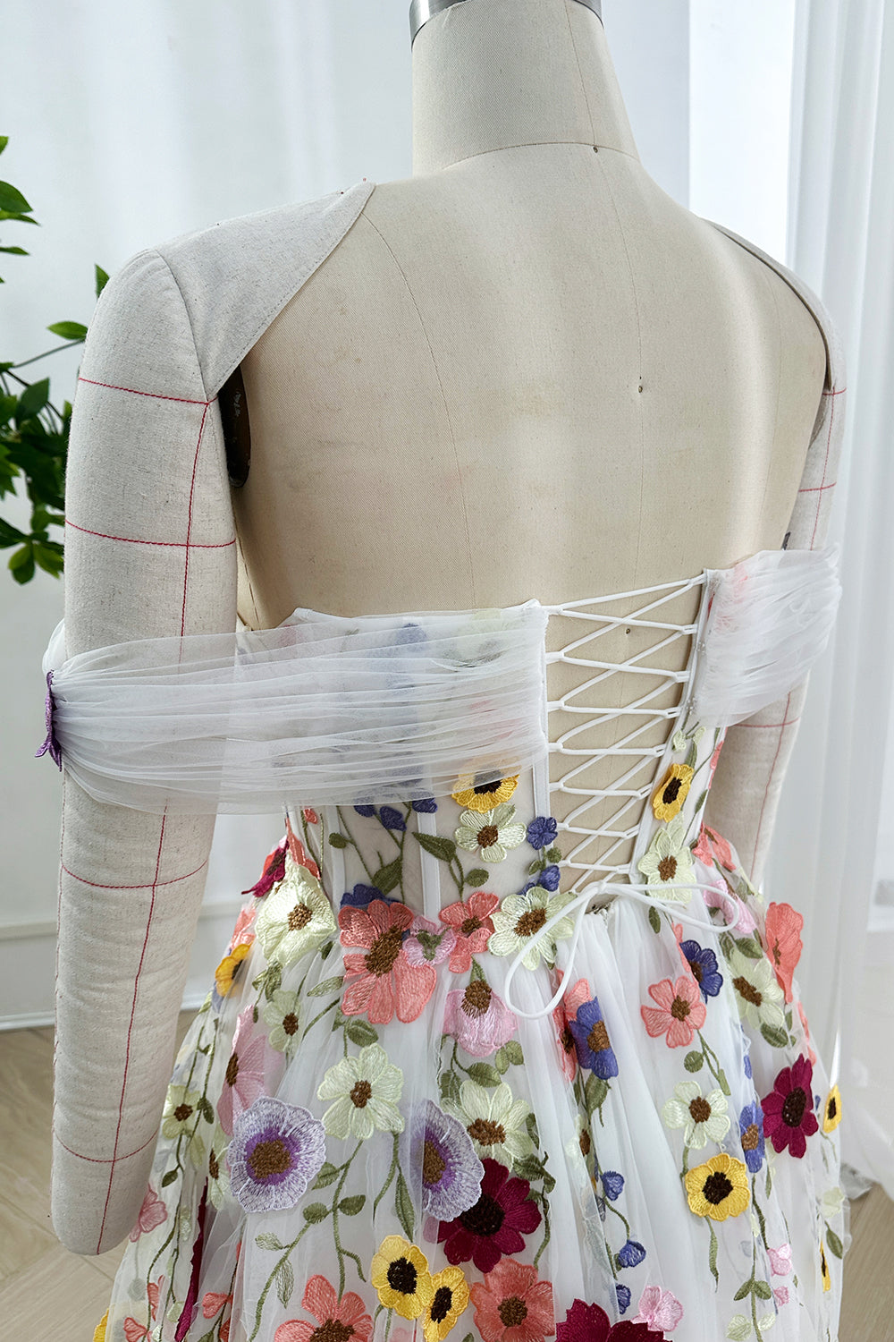 Laceup corset closure highlighting sculpted waistline against soft backdrop emphasizing handcrafted structural precision