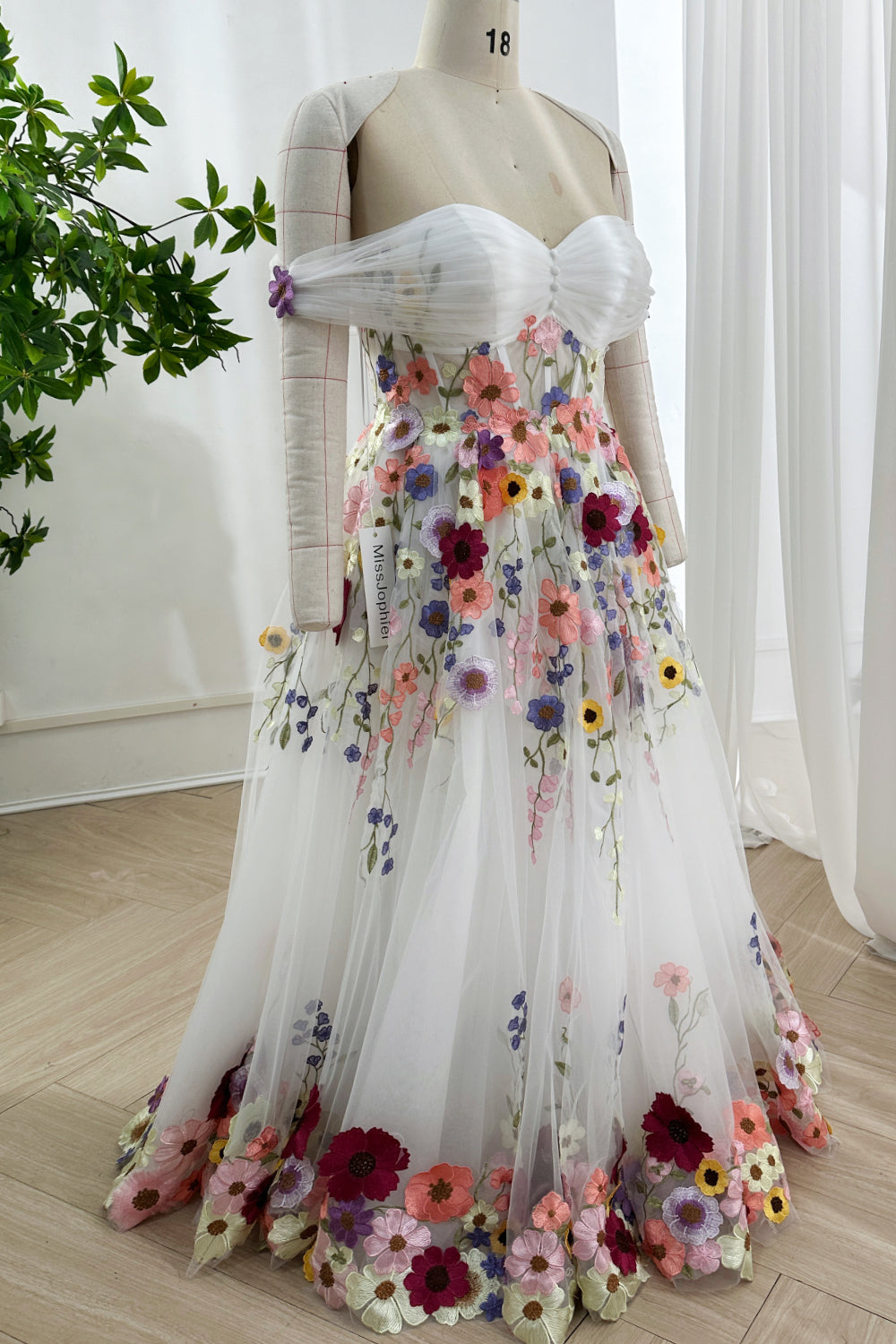 Meadowinspired three dimensional florals flowing gracefully across airy silhouette capturing enchanting springtime aesthetic