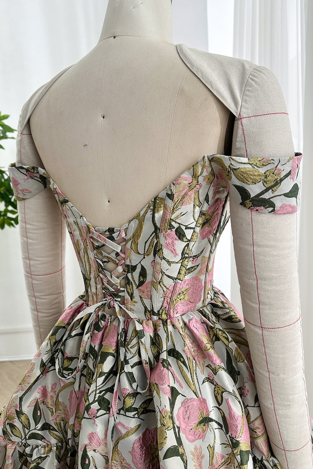 Angled backside glimpse ribbon tie fitted shape dramatic flounce ornate stems luxury partywear fashion editorial ambiance