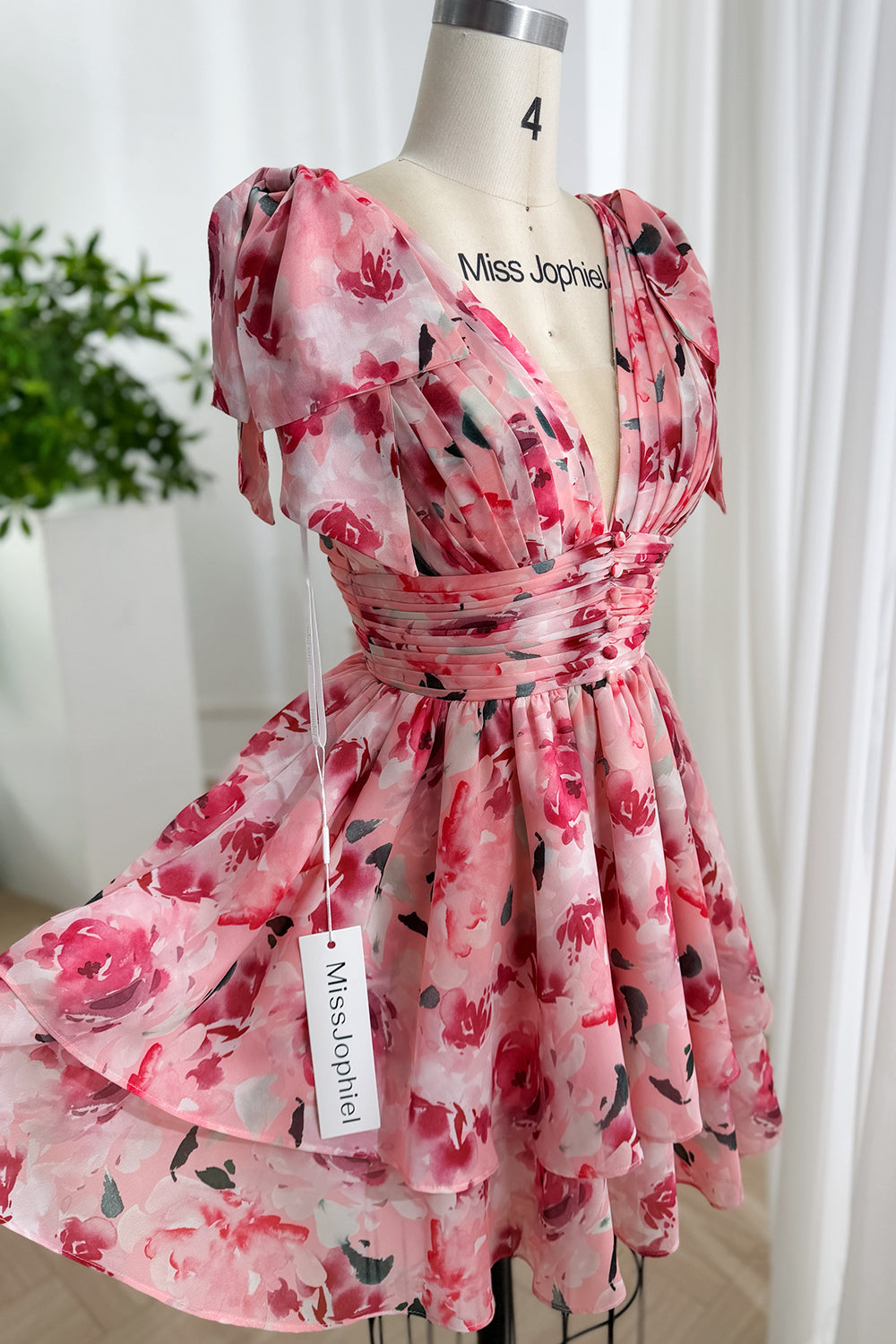 Rosy watercolor silhouette mannequin display featuring plunging bodice twirling hemline feminine boutique portrait graceful charm