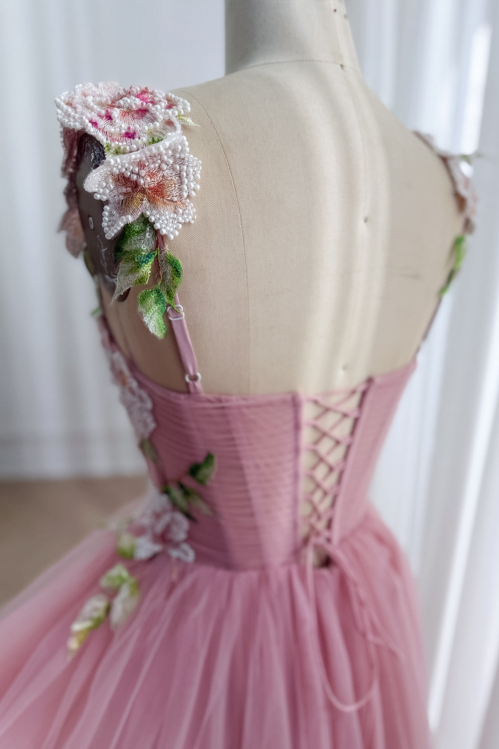 Rear view highlights adjustable crisscross closure, airy illusion sleeves, soft ballet hemline during engagement photoshoot..