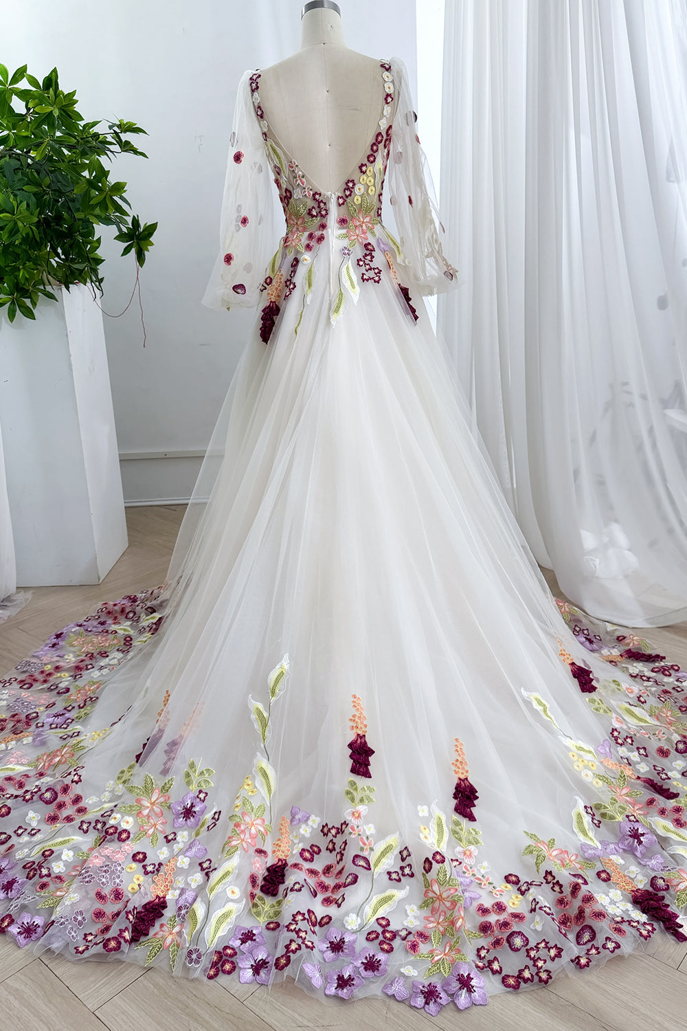 Graceful rearview displaying sweeping hem artistry accented lavender petals framing dramatic openback composition elegantly