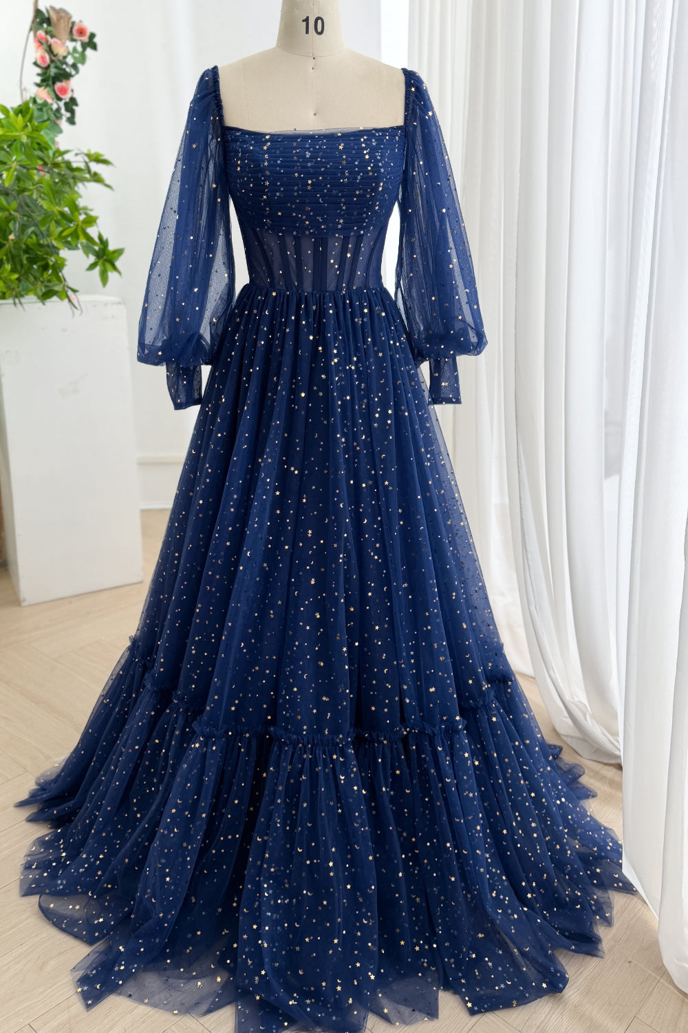 Complete midnight celestial tulle gown showing golden constellations, squared bodice, billowy sleeves, tiered sweeping train.