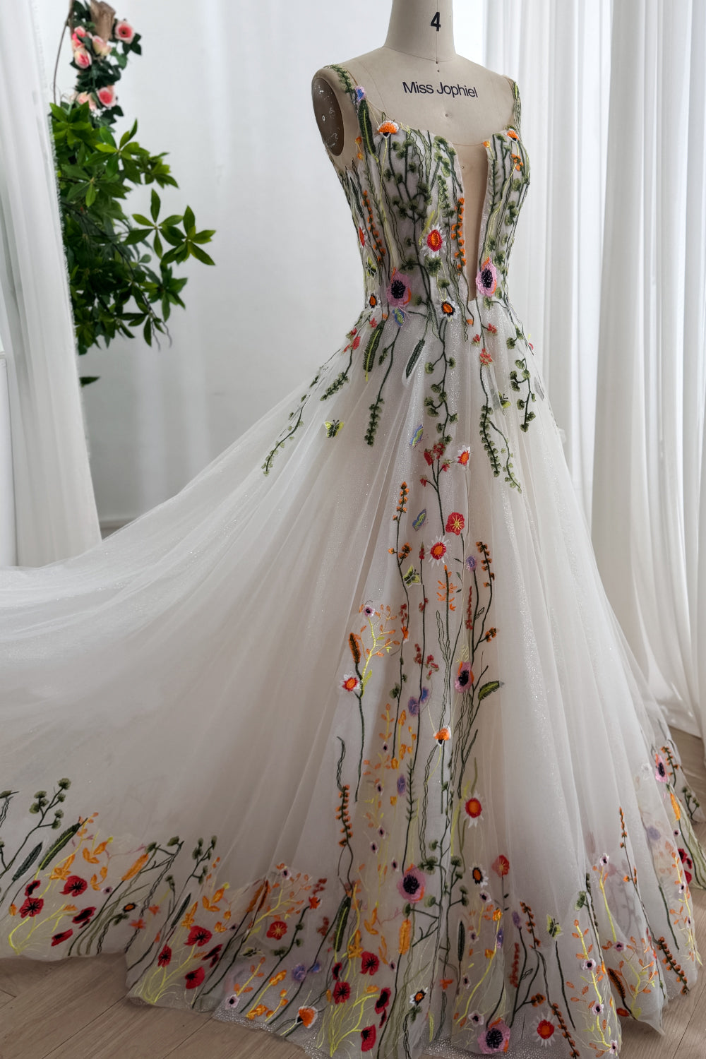 Ivory wildflower embroidered glitter tulle wedding gown with plunging illusion bodice flowing chapel train studio front view.