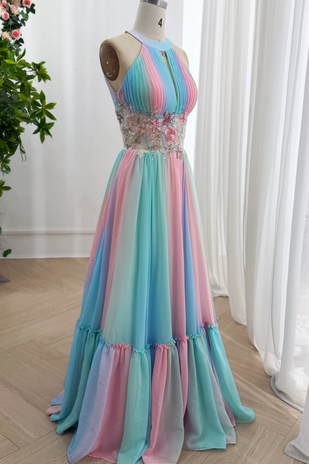 Colorful A-line formalwear reveals sheer appliqued midriff, laced reverse, soft train over parquet showroom flooring gallery.